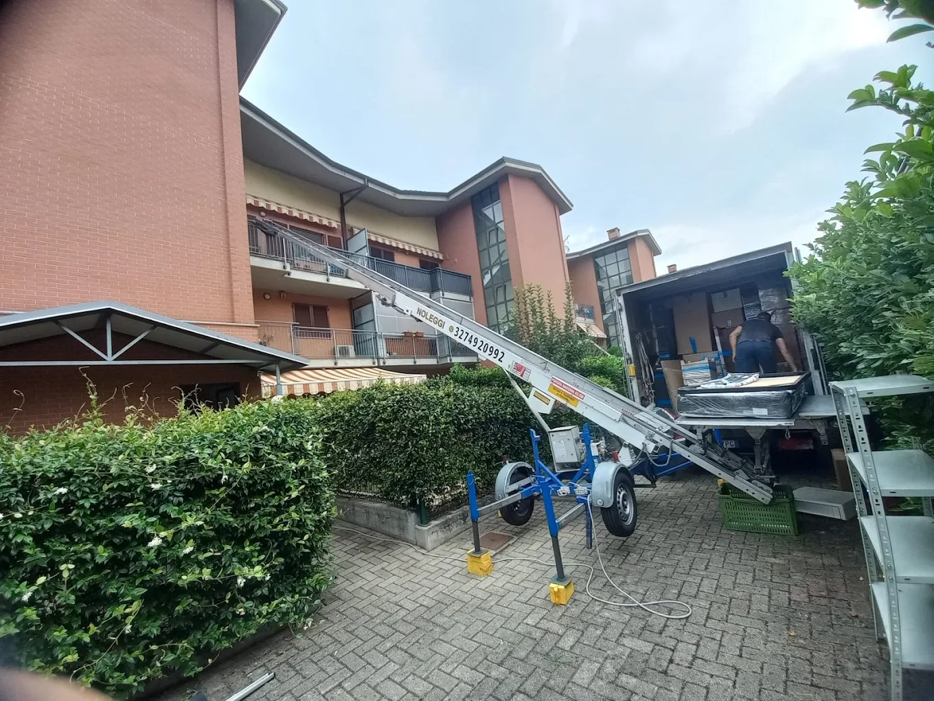 Elevatore esterno al lavoro durante un trasloco in cortile